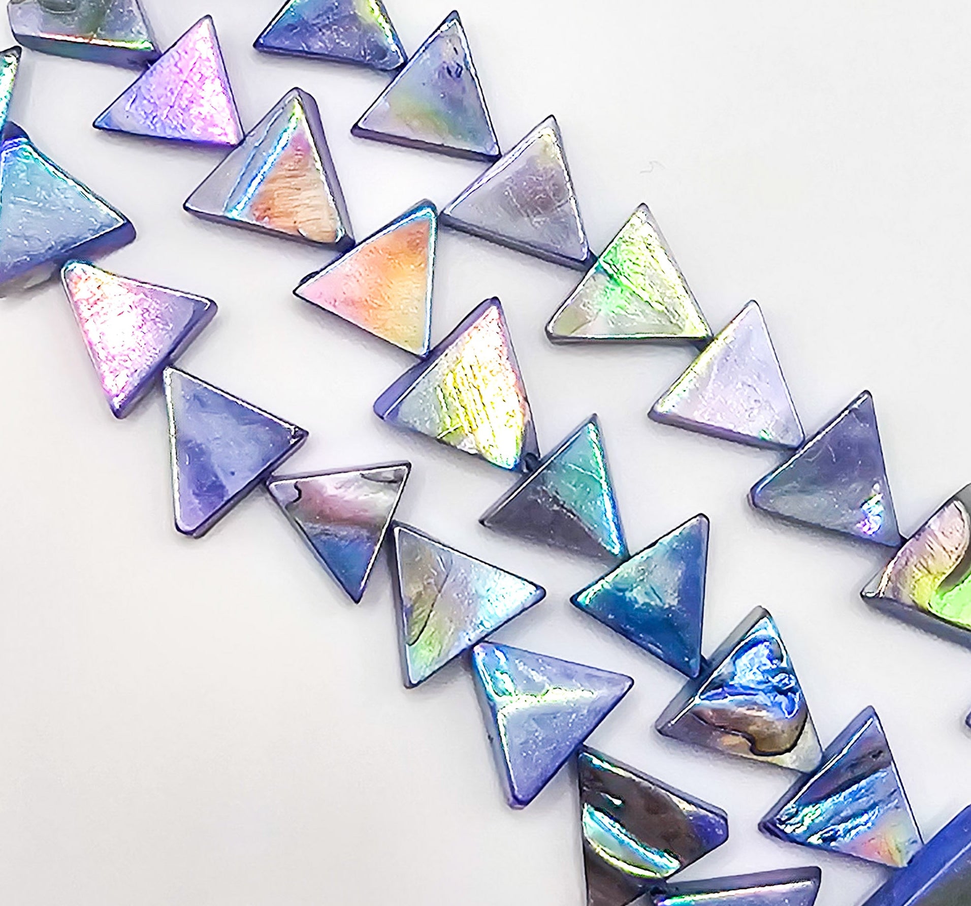 Iridescent triangle-shaped stones on a white background